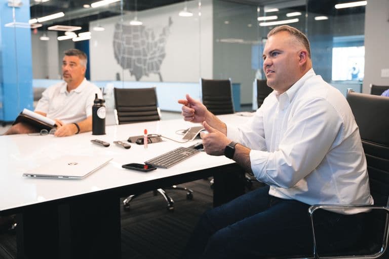Two Conduit strategists talking through a campaign at the conference table
