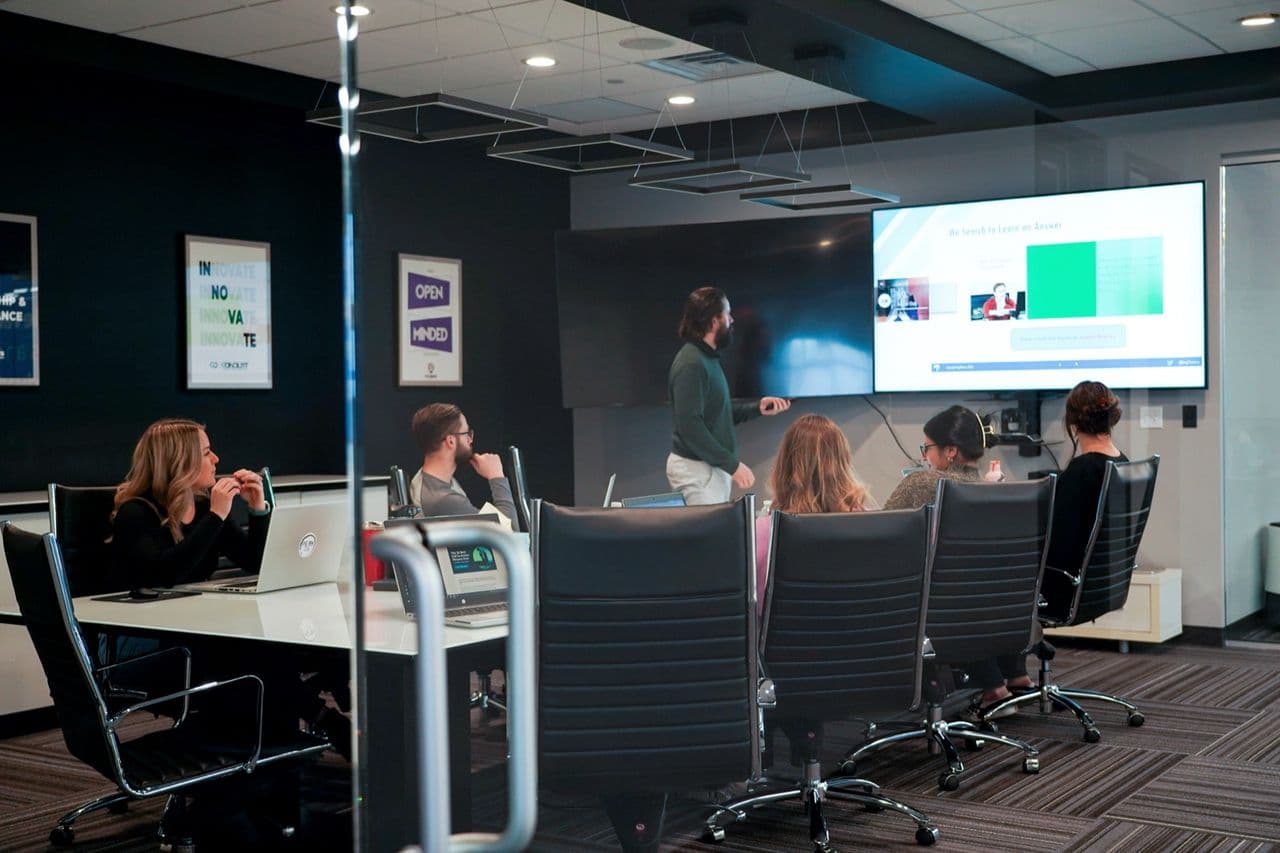 A Conduit team meeting in a glass conference room