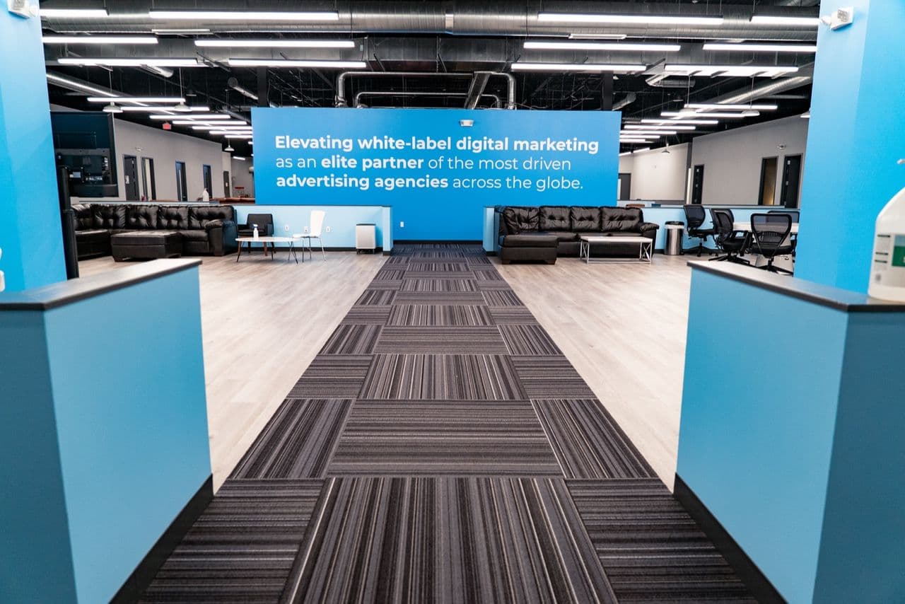 The Conduit office floor with the brand wall in the background