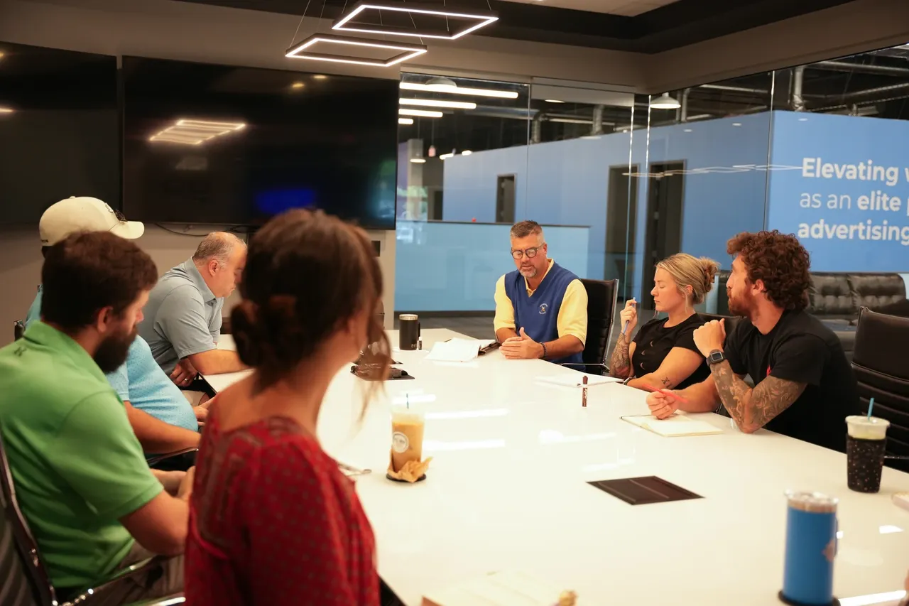 Conduit team members working through a partner brief at the boardroom table