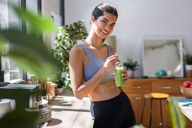Health Shot: a woman smiling with a wellness shot