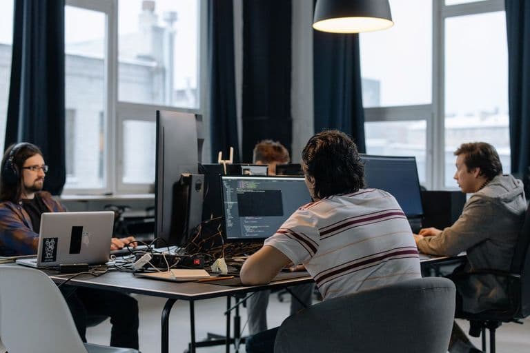 A software team working at monitors in a technology office