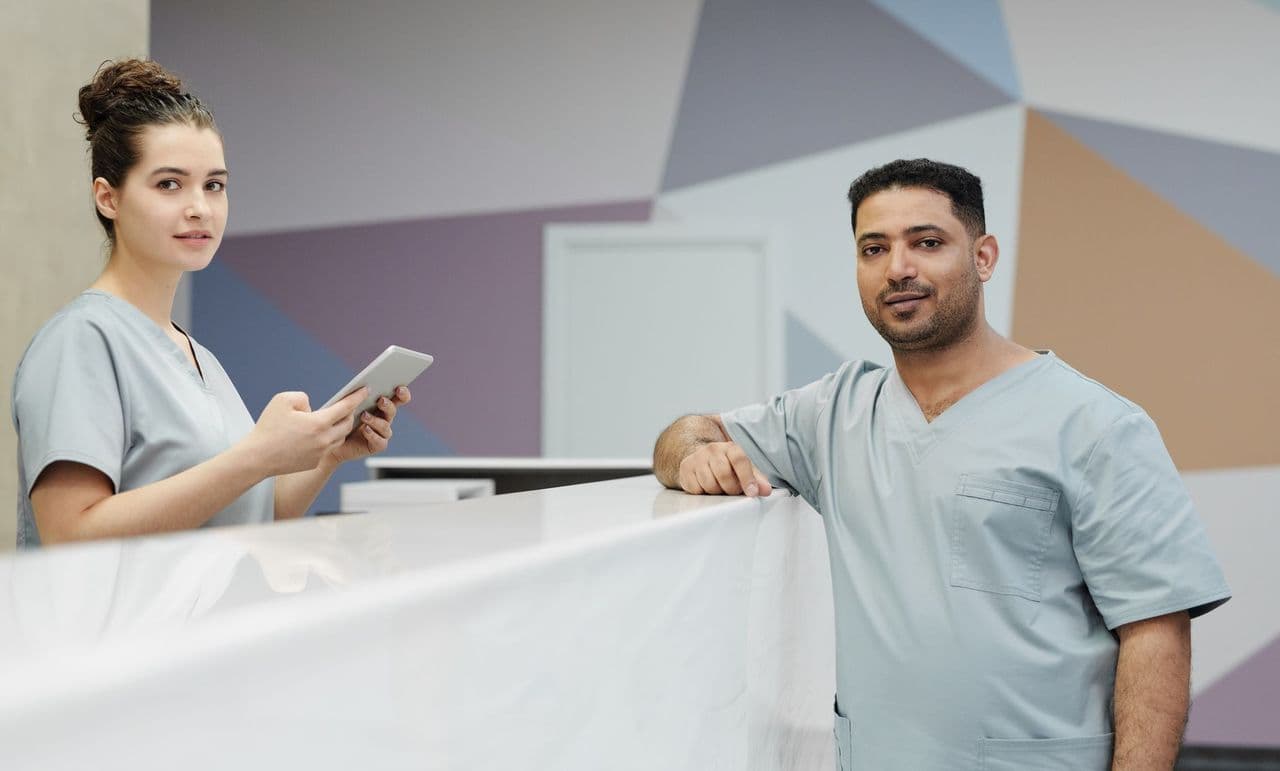 Clinic staff in scrubs at a modern reception desk