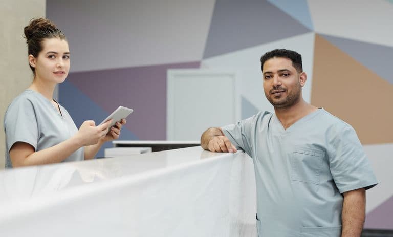 Clinic staff in scrubs at a modern reception desk