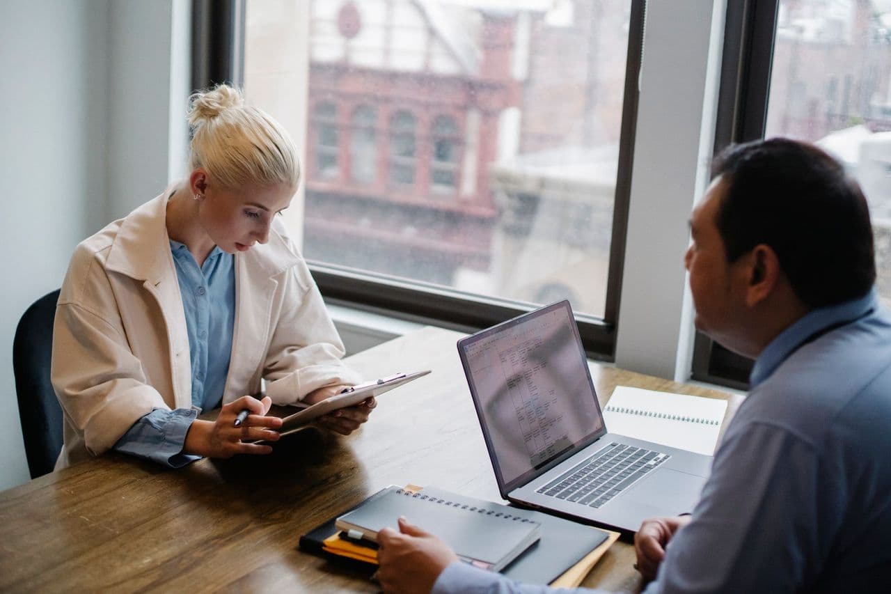 A consultant reviewing figures with a client at a workspace