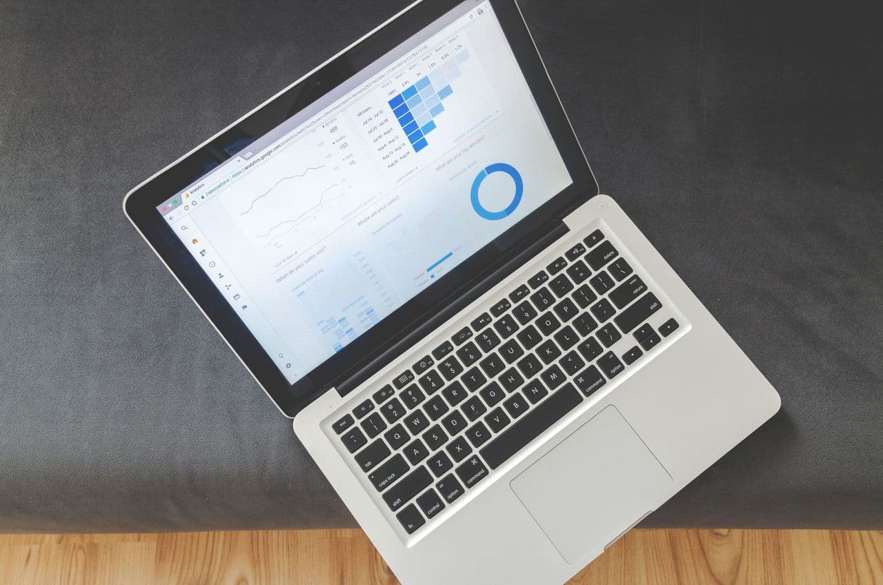 Overhead view of a laptop showing data visualizations and charts on its screen