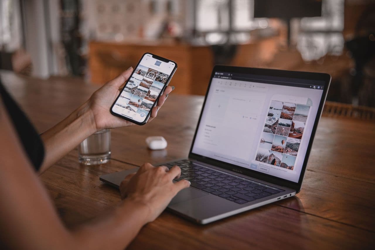 Woman edits social media content on phone and laptop at a cafe in Bali