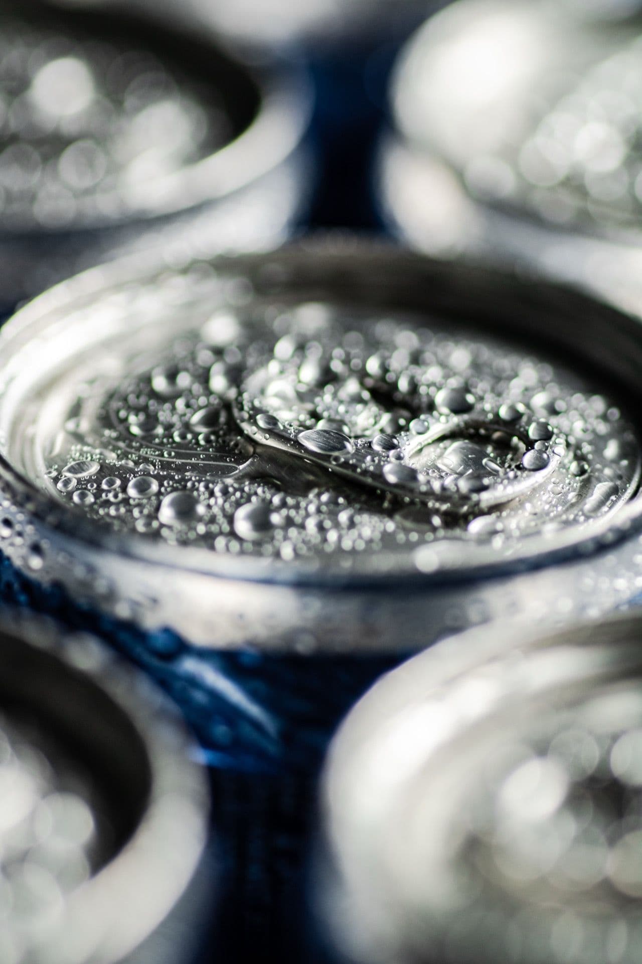 Ice-cold soda cans beaded with condensation